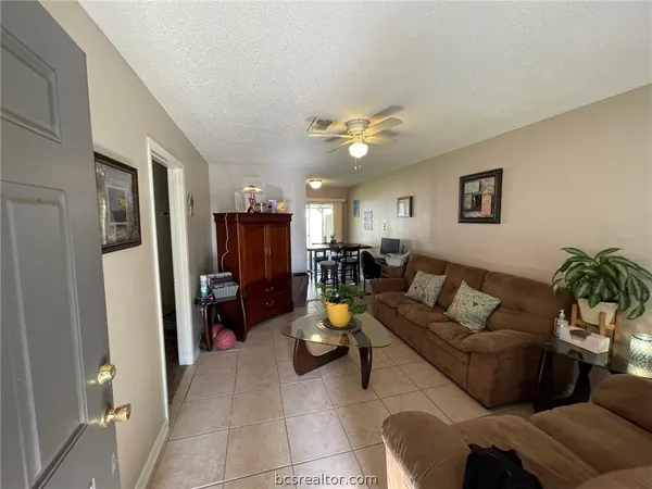 a living room with furniture and kitchen view