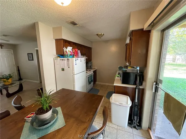 a dining room with furniture and a potted plant
