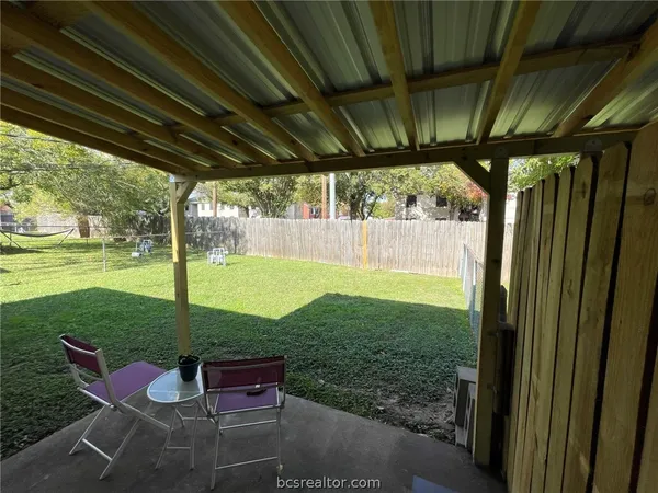 a view of a porch with chairs and backyard