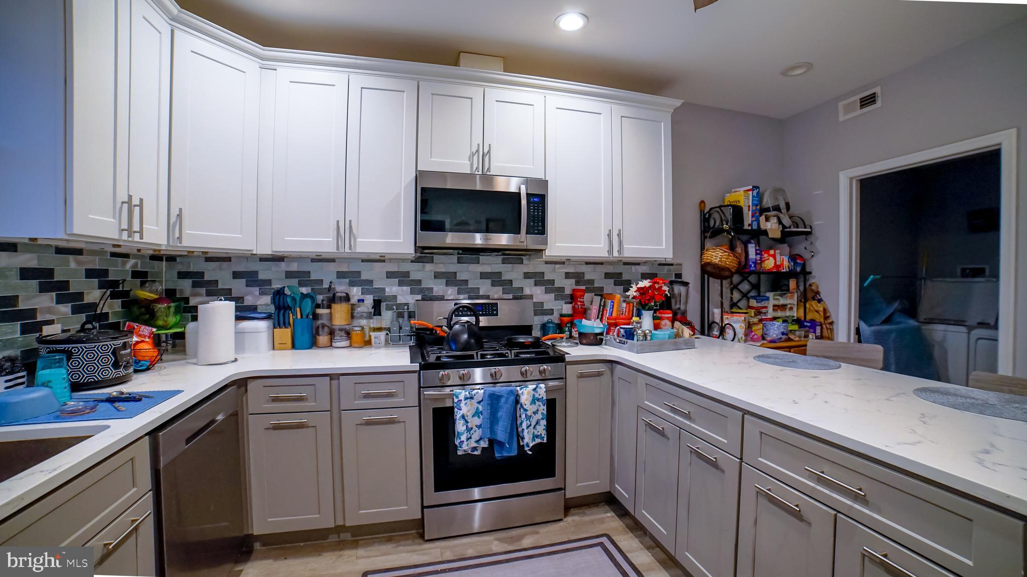 5635 North 10th Street Philadelphia, PA 19141 - Photo 3 of 13 a kitchen with stainless steel appliances granite countertop a sink dishwasher stove and cabinets