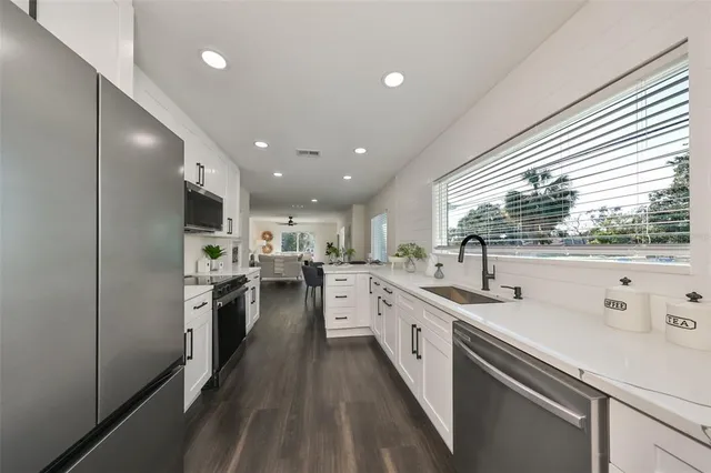 a kitchen with a sink stainless steel appliances and cabinets