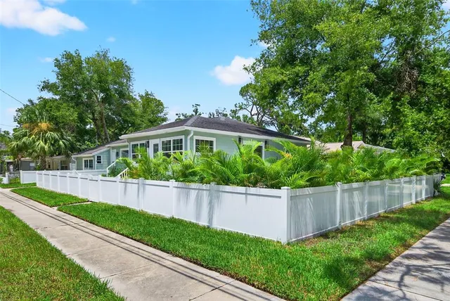 a front view of a house with a yard and potted plants