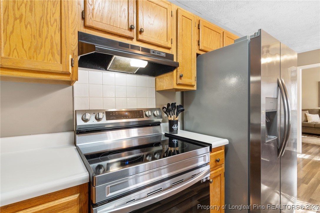 5004 Summer Ridge Road Fayetteville, NC 28303 - Photo 15 of 31 a kitchen with stainless steel appliances granite countertop a refrigerator and a stove top oven