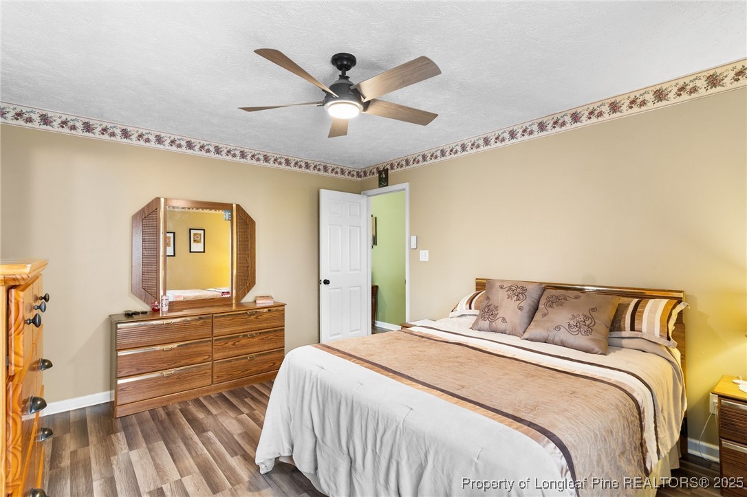 5004 Summer Ridge Road Fayetteville, NC 28303 - Photo 17 of 31 a bedroom with a bed and a chandelier