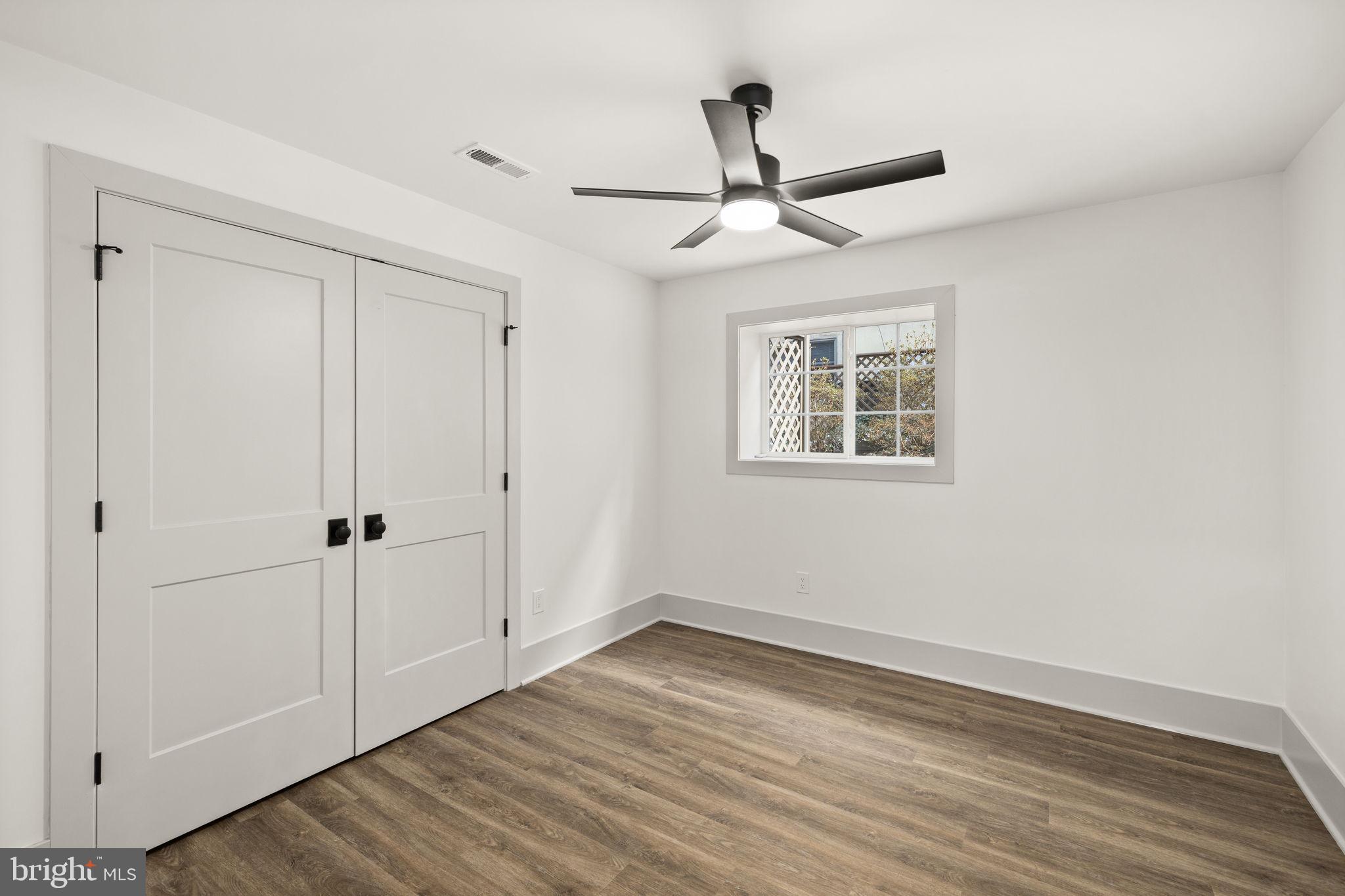 116 Washington Street Locust Grove, VA 22508 - Photo 82 of 130 an empty room with wooden floor ceiling fan and windows