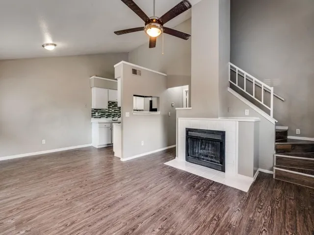 a view of a livingroom with wooden floor a fireplace and entryway