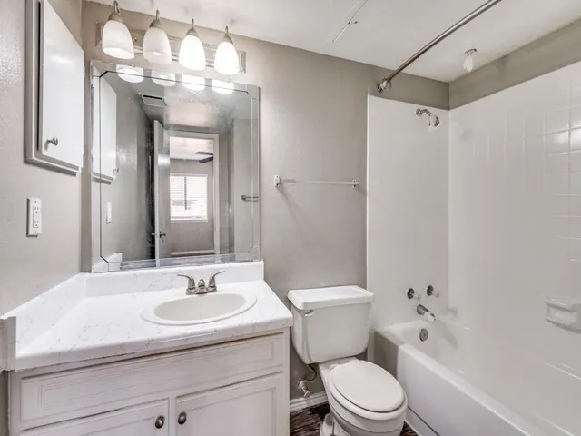 a bathroom with a sink toilet vanity and shower