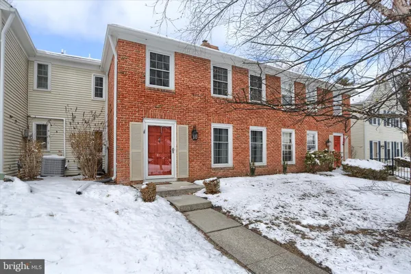 a front view of a house with a yard covered with snow