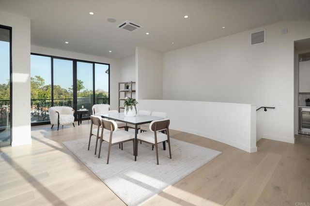 a dining room with furniture and a floor to ceiling window