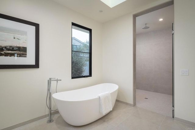 a bedroom with a bed a couch and large window