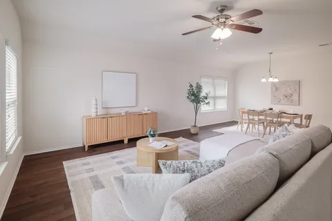 a living room with furniture flowerpot and a chandelier