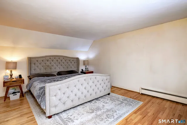 a bedroom with a bed and wooden floor