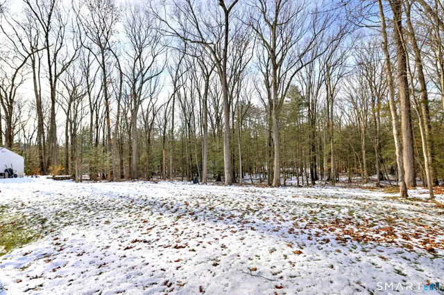a white house covered with snow in front of house