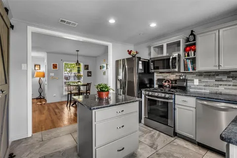 a kitchen with stainless steel appliances granite countertop a refrigerator and a stove top oven