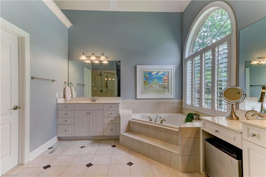5501 Gray Leigh Drive Oak Ridge, NC 27310 - Photo 15 of 30 The Master Bath has two separate vanities and plenty of drawer and cabinet space. Plantation Shutters on Palladian window. Jetted tub, separate shower with updated frame-less glass surround.