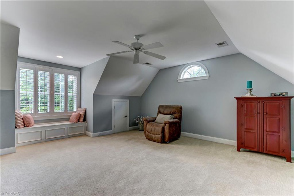 5501 Gray Leigh Drive Oak Ridge, NC 27310 - Photo 21 of 30 Spacious Bonus room has wall to wall carpeting, ceiling fan, Plantation Shutters, and window seat with storage.