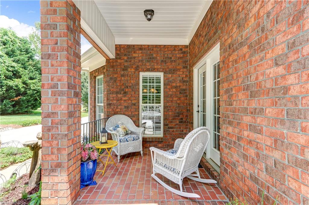5501 Gray Leigh Drive Oak Ridge, NC 27310 - Photo 23 of 30 The covered back porch has brick flooring and light fixture.