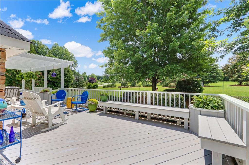 5501 Gray Leigh Drive Oak Ridge, NC 27310 - Photo 24 of 30 The back deck offers multiple entertainment venues. Shown here is open area with built in benches and planters.