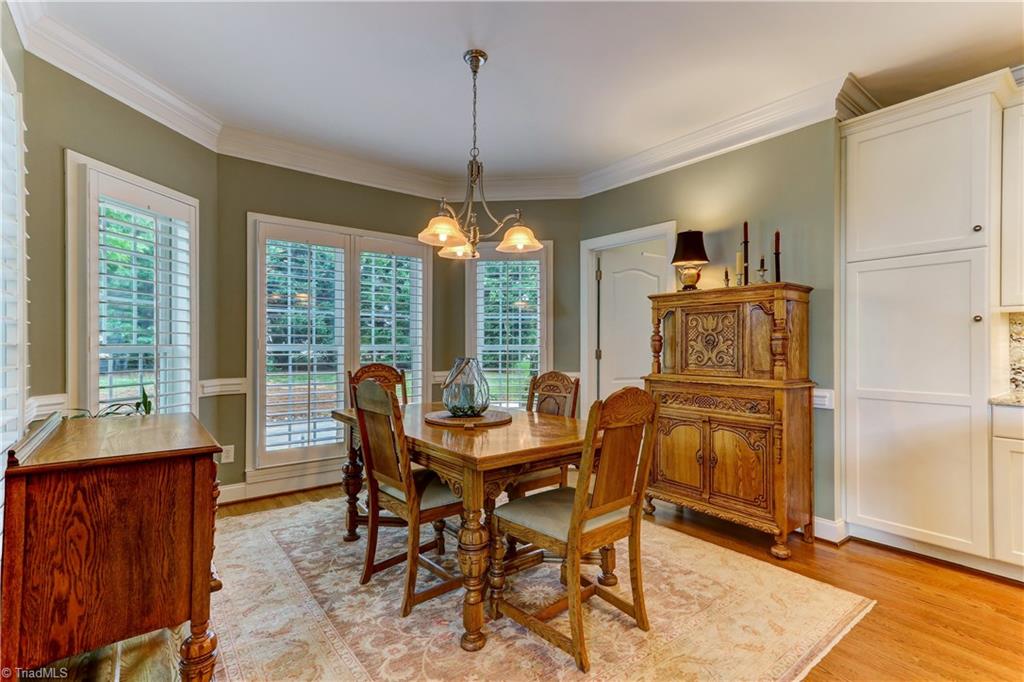 5501 Gray Leigh Drive Oak Ridge, NC 27310 - Photo 10 of 30 The Breakfast Room. Large windows with Plantation Shutters, chair rail molding, central chandelier, and crown molding. Door leads to laundry room that has large sink.