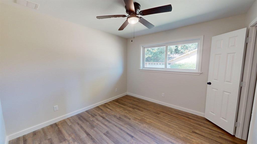 1110 Mill Run Road Athens, TX 75751 - Photo 15 of 24 an empty room with wooden floor ceiling fan and windows