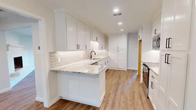 a kitchen with kitchen island a sink appliances and cabinets