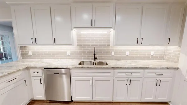 a kitchen with white cabinets and white appliances