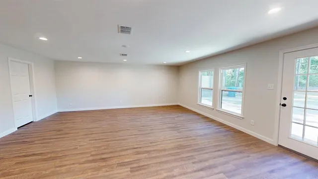 wooden floor in an empty room with a window