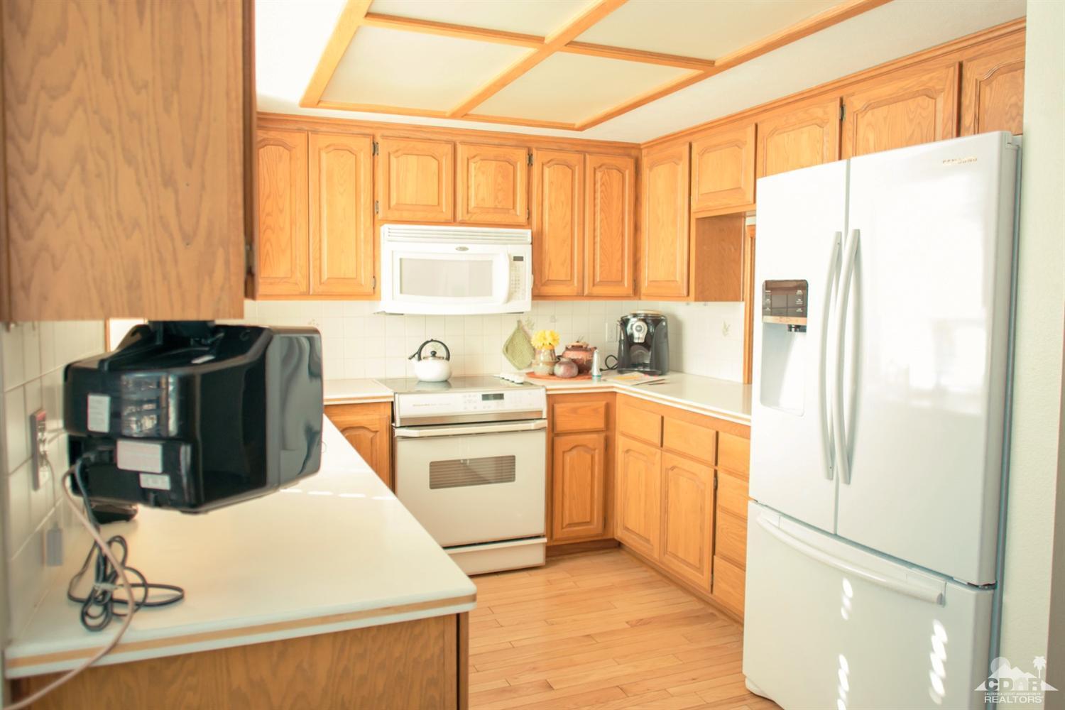 25037 Cougar Road Idyllwild, CA 92549 - Photo 61 of 73 a kitchen with a refrigerator a stove a microwave and cabinets