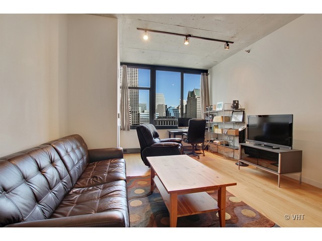 235 West Van Buren Street, Unit 3518 Chicago, IL 60607 - Photo 3 of 9 a living room with furniture a rug and a flat screen tv