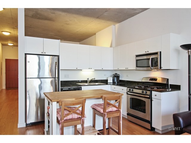 235 West Van Buren Street, Unit 3518 Chicago, IL 60607 - Photo 4 of 9 a kitchen with stainless steel appliances a stove a sink and a refrigerator