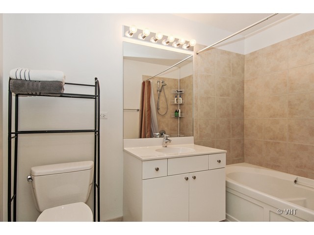 235 West Van Buren Street, Unit 3518 Chicago, IL 60607 - Photo 6 of 9 a bathroom with a sink a toilet and shower