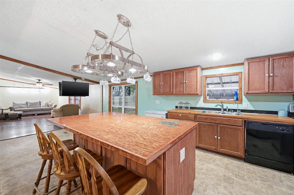 2421 Edwards Road Van Alstyne, TX 75495 - Photo 11 of 40 a kitchen with stainless steel appliances granite countertop a kitchen island a stove a table and chairs in it
