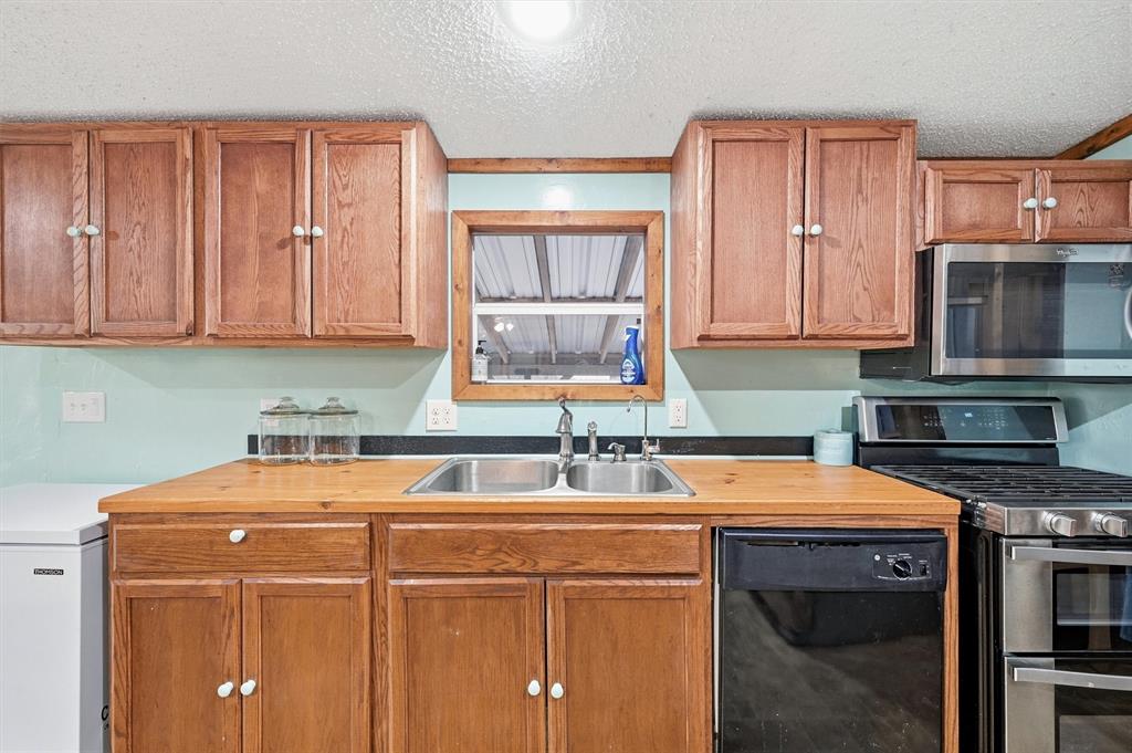 2421 Edwards Road Van Alstyne, TX 75495 - Photo 12 of 40 a utility room with stainless steel appliances a stove a sink and a microwave