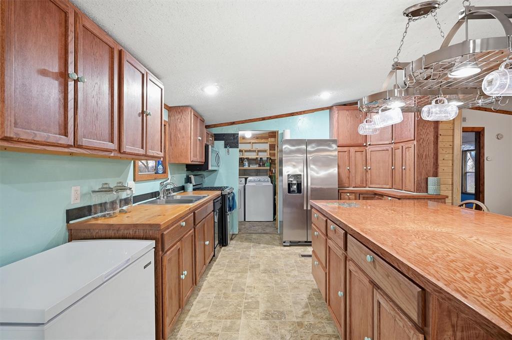 2421 Edwards Road Van Alstyne, TX 75495 - Photo 13 of 40 a kitchen that has a lot of cabinets in it and stainless steel appliances