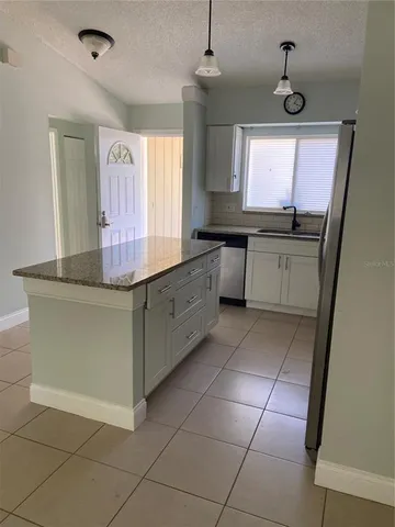 a kitchen with a sink window and cabinets