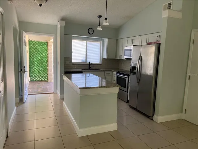 a kitchen with stainless steel appliances granite countertop a refrigerator and a sink