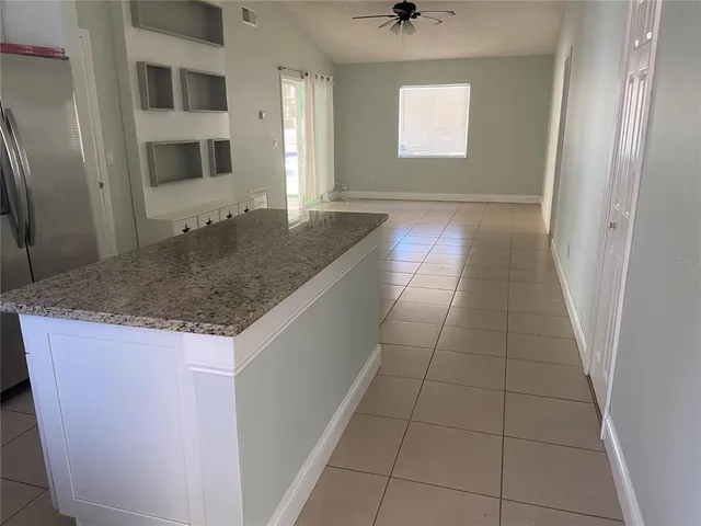 a large white kitchen with a sink and refrigerator