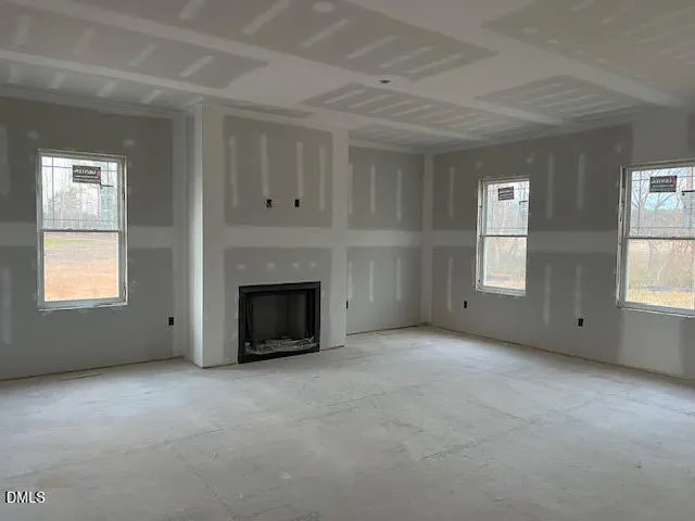 an empty room with windows and fireplace