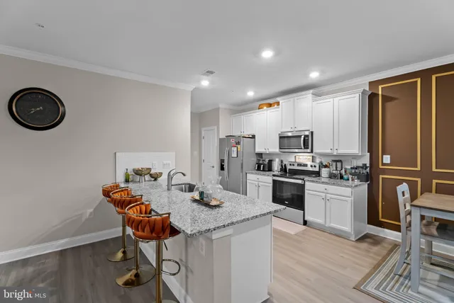 a kitchen with a table chairs refrigerator and cabinets