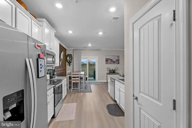 a kitchen with stainless steel appliances granite countertop a refrigerator and a sink