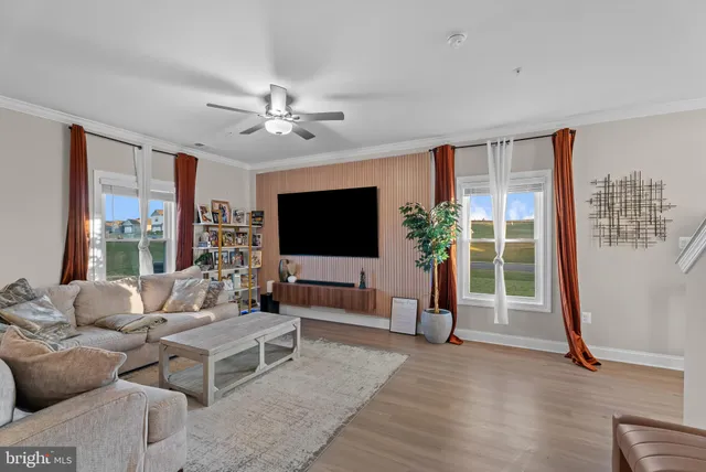 a living room with furniture a flat screen tv and a large window