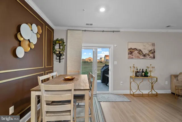 a living room with a table and chairs with wooden floor