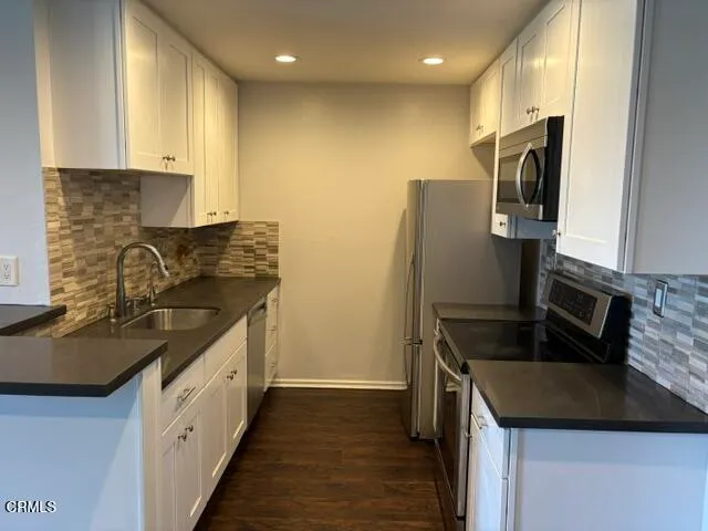 a bathroom with a granite countertop sink a toilet a mirror and shower