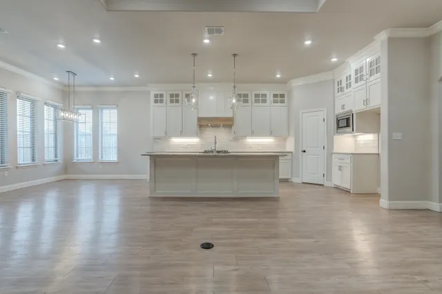 a kitchen with kitchen island a counter top space a sink stainless steel appliances and cabinets
