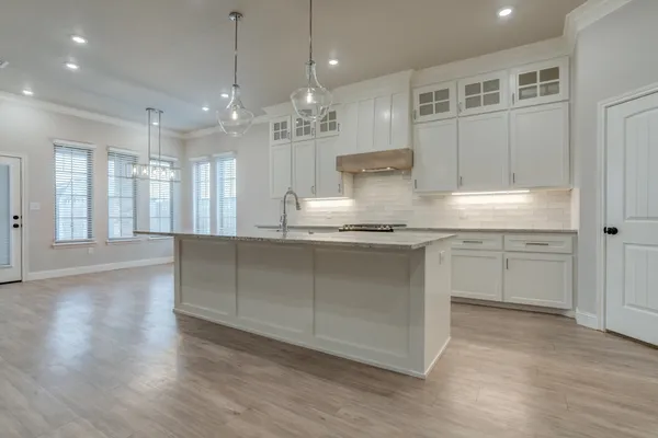 a kitchen with granite countertop a sink a counter top space stainless steel appliances and cabinets