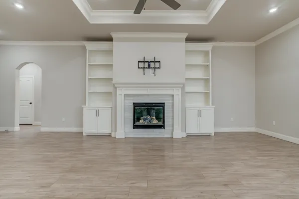 a view of an empty room with a fireplace and a window