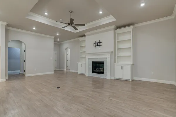 an empty room with wooden floor and a fireplace