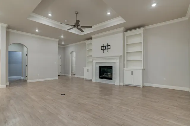 an empty room with wooden floor and a fireplace