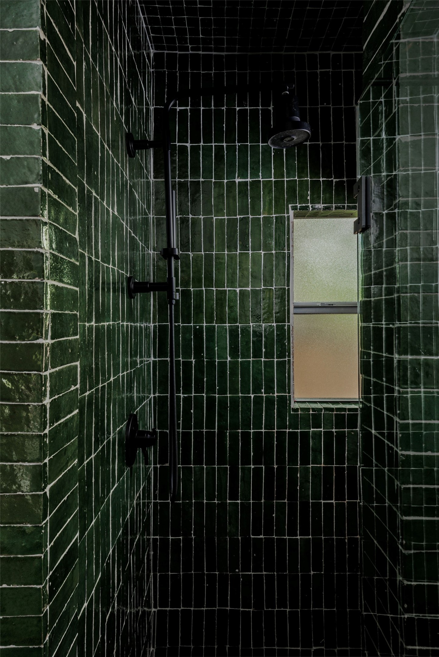 1605 Maple Avenue Austin, TX 78702 - Photo 24 of 33 Shower enclosure featuring dark green subway tiles, a matte black shower head, and a transom window
