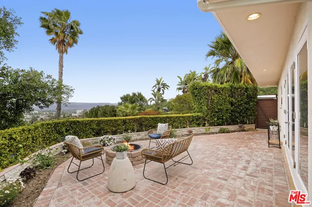 a view of a house with backyard sitting area and garden